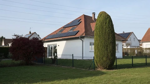 Maison individuelle moderne avec panneaux solaires photovolta&iuml;ques install&eacute;s sur toiture en tuiles rouges