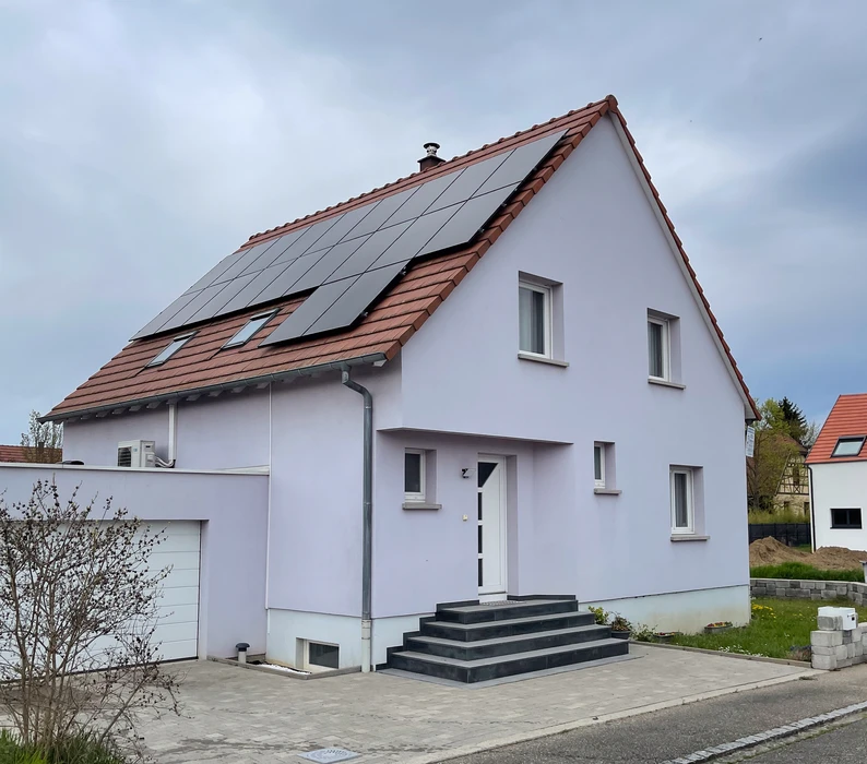 Maison individuelle moderne avec façade blanche et toiture en tuiles rouges