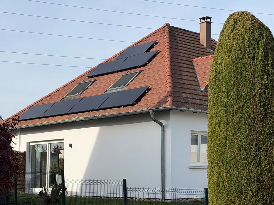 Maison résidentielle avec installation de panneaux solaires photovoltaïques sur toiture en tuiles rouges