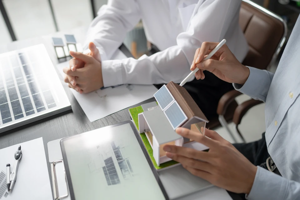 &Eacute;lectricien en combinaison bleue travaillant dans local technique, manipulant pince amp&egrave;rem&eacute;trique rouge pr&egrave;s tableau &eacute;lectrique